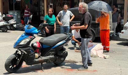 Kazada yaralanan genç kadına esnaftan şemsiyeli destek