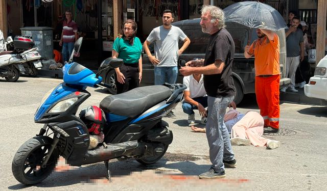 Kazada yaralanan genç kadına esnaftan şemsiyeli destek